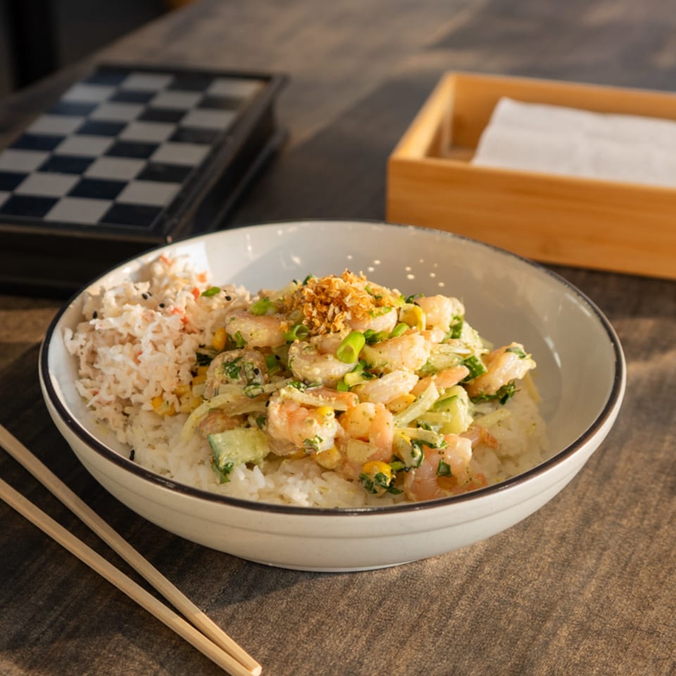 Hana Poke's shrimp poke bowl with rice, cucumber, corn, and green onions, with chopsticks nearby.